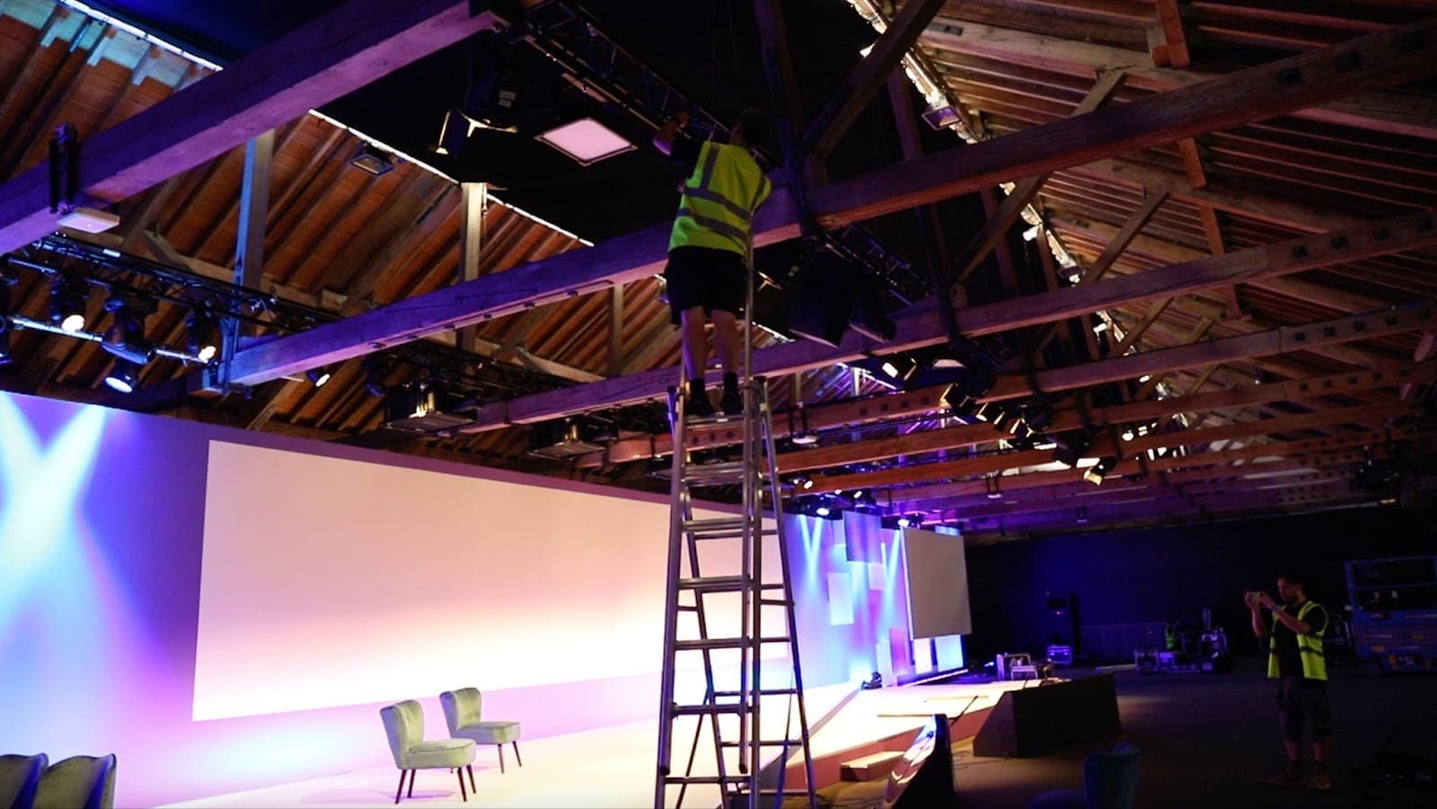 A Solder technician installing equipment in the stage rigging