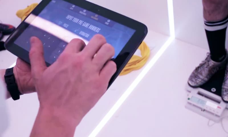 Photo of a player being weighed and having their details registered in the sport scientist's tablet app before kick-off